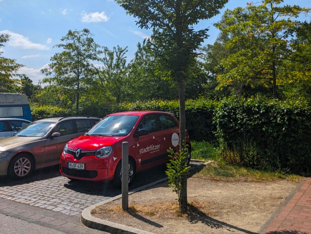 Rotes Auto von stadtmobil Hannover, der stadtflitzer, steht in praller Sonne und Hitze
